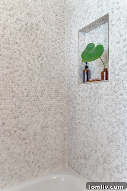 Detail shot of the guest bathroom's floating vanity and mirror, with the botanical wallpaper providing a lush backdrop.
