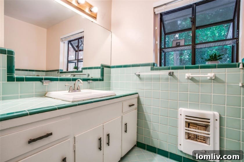 A luxurious black primary bathroom with large format tiles, a floating shelf, and a motion-sensored mirror.