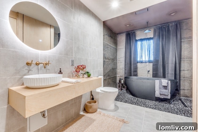 View of the black bathtub and matching fixtures in the primary bathroom, emphasizing the minimalist and spa-like atmosphere.