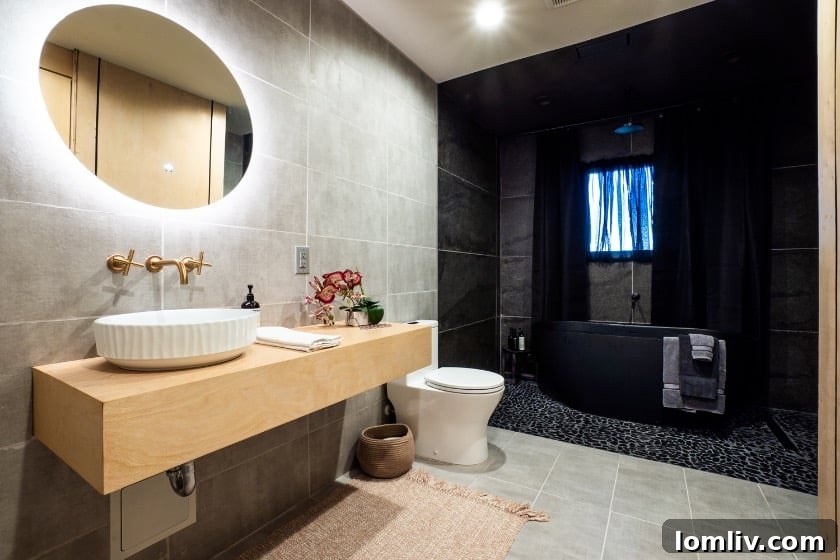 A closer look at the unique stone accent wall and floating wooden shelf in the primary bathroom, adding texture and warmth.