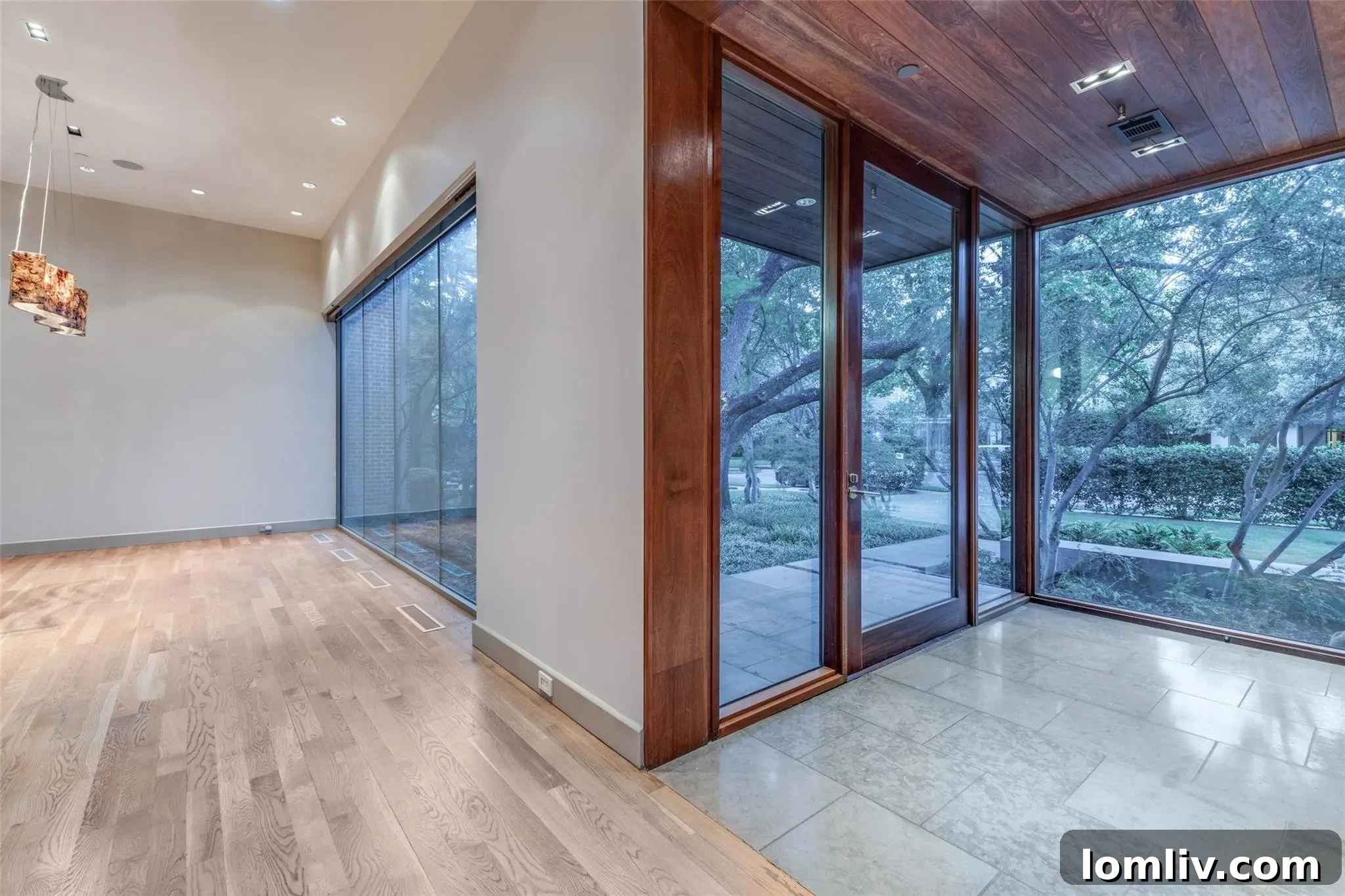 Spacious living area of the luxury home, featuring large windows and abundant natural light, overlooking green landscape