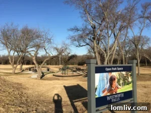 Expansive seven-acre community park at Westworth Falls, featuring playscapes, walking paths, and shaded seating.