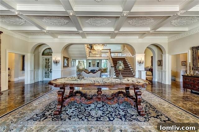 Grand foyer of The Baldridge House with marble floors and sweeping staircase