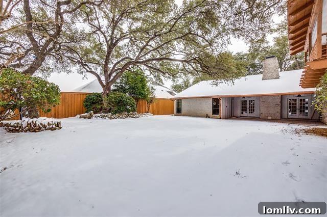 A wide view of the beautifully landscaped backyard and exterior of the home