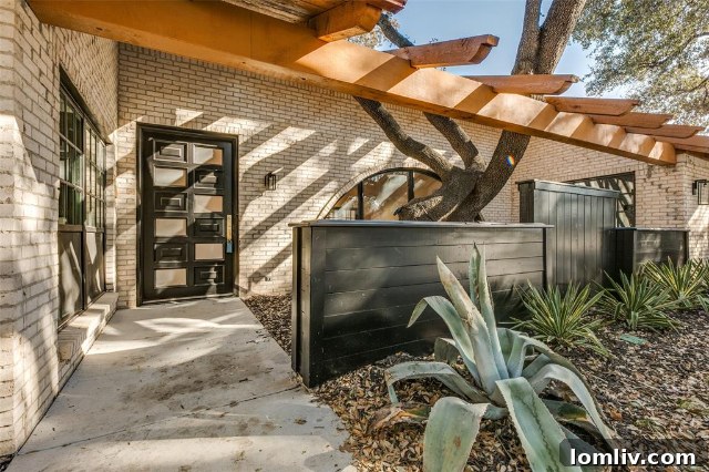 Front view of the renovated Spanish Ranch home with lush landscaping