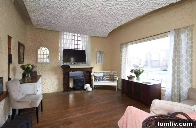Living area with a large picture window and stucco walls, blending classic and quirky elements