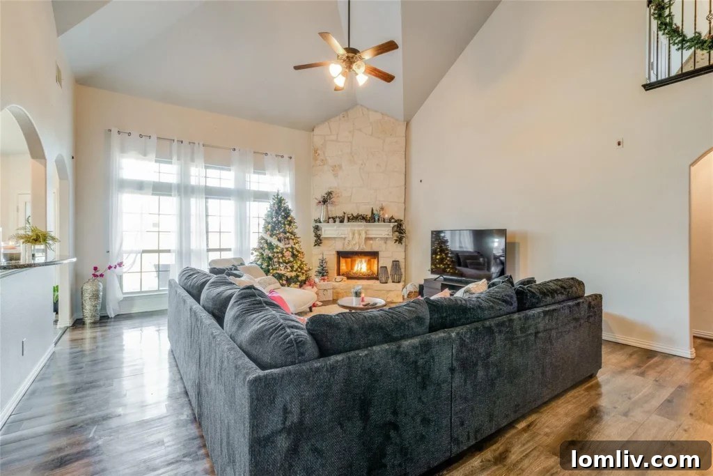 Spacious living room with large windows, offering natural light and a comfortable atmosphere for family gatherings.