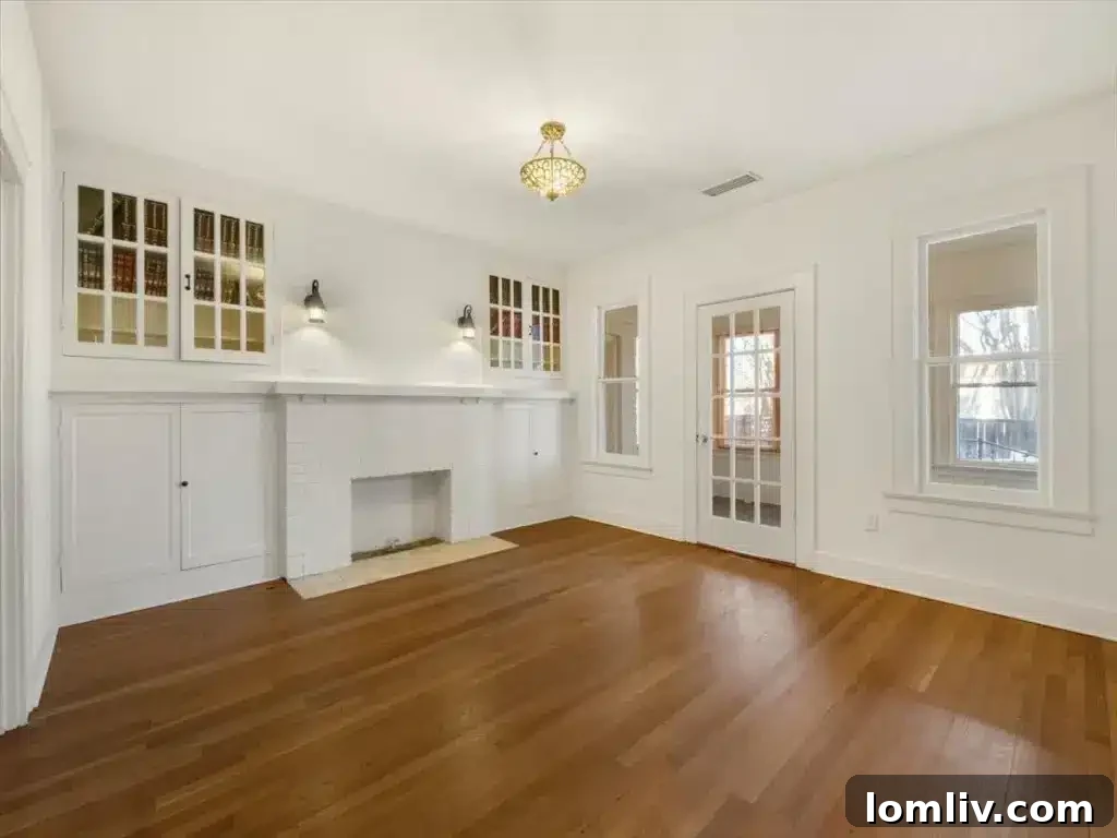 This Junius Heights Prairie-Style Home's Original Details Are A Vintage Lover's Dream 4 Elegant interior view of the living room, featuring original hardwood floors and a vintage chandelier.