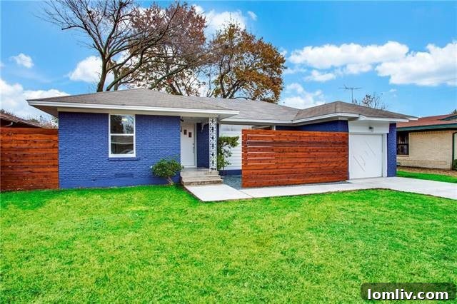 Front exterior of 10208 San Lorenzo Drive showcasing the bold cobalt blue painted brick and modern cedar privacy wall