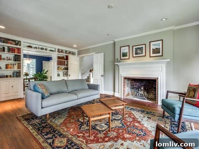 Spacious living room with a grand wood-burning fireplace and floor-to-ceiling bay windows