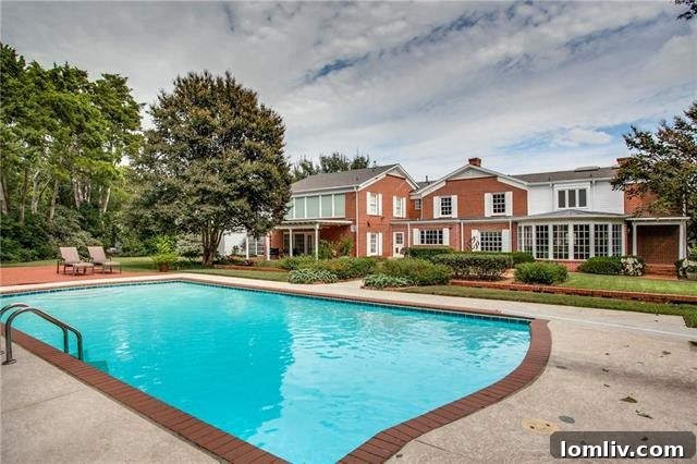 Panoramic view of the expansive backyard and the grand rear facade of the mansion
