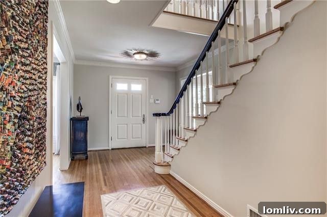 Elegant foyer with sweeping staircase at The Pearl of Preston Hollow