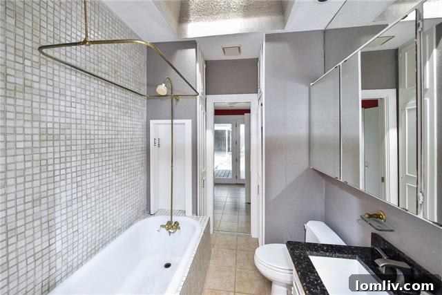 Renovated Bathroom with Brass Fixtures and Skylight