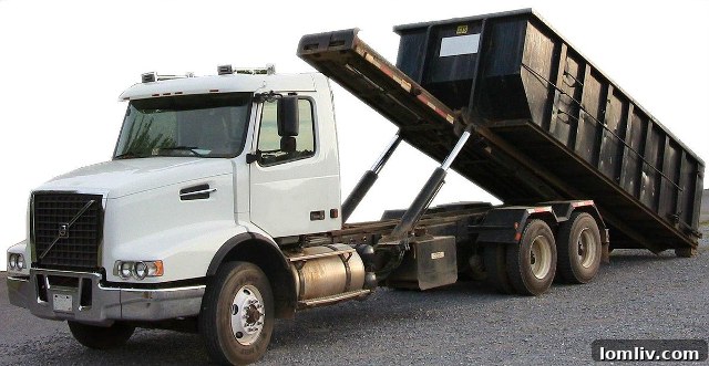 Construction debris being loaded into a dumpster, illustrating the ongoing renovation and its impact.