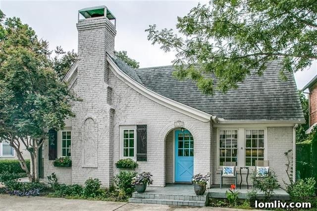 Charming exterior of a Tudor home with brick and mature landscaping.