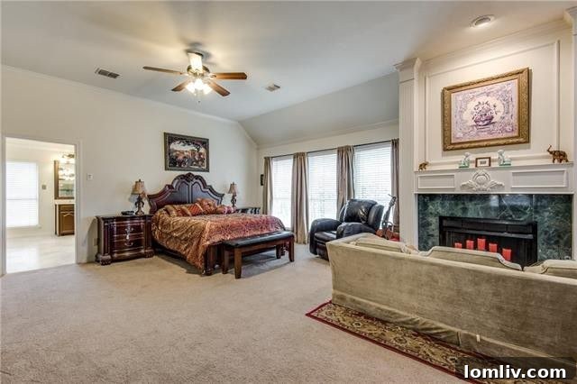 Spacious master bedroom featuring a dedicated sitting area and elegant fireplace for relaxation