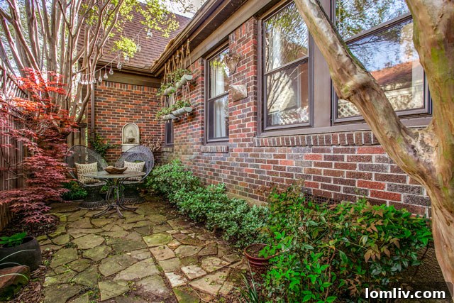 Hollywood Heights Tudor: A Designer's Vision Realized 27 Beautifully landscaped backyard with lush greenery and mature trees, showcasing Ben Larkin's garden design at 707 Cordova.