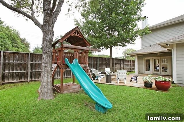 Lush backyard with a flagstone patio and gas firepit, perfect for entertaining in Ridgewood Park