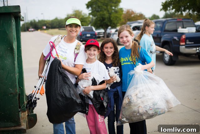 Volunteers enthusiastically picking up trash in a community park, demonstrating active participation in an Earth Day clean-up event.