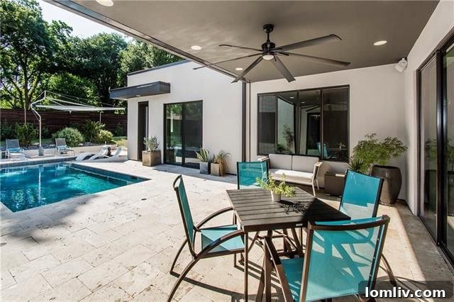 Covered outdoor patio with open wall of windows from the living room and pool view