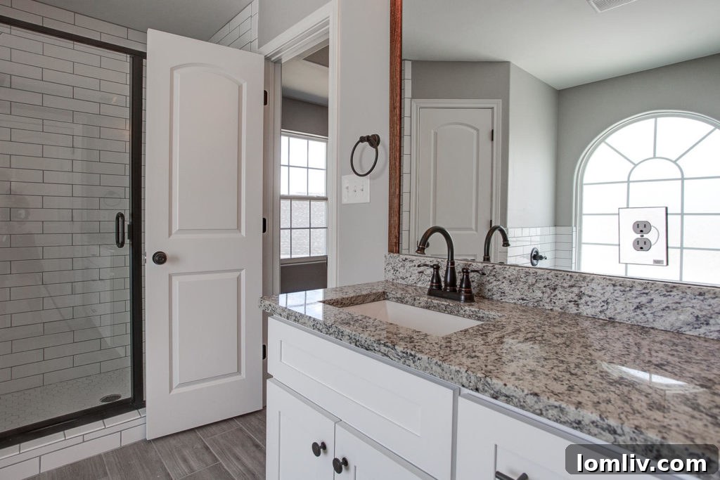 Luxurious master bathroom in 2016 Shane Avenue with tiled shower, granite counters, and undermount sinks.