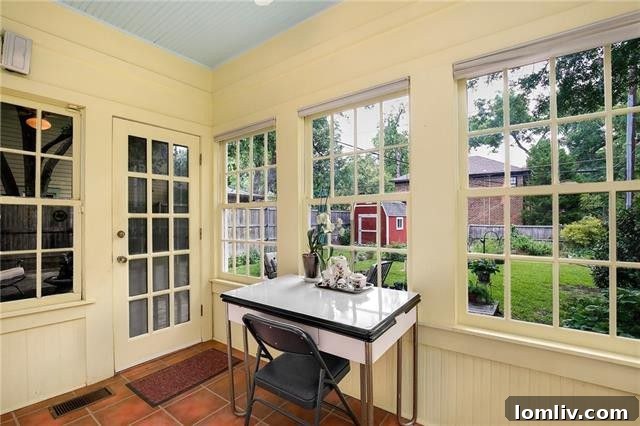 French doors opening to an expansive rear deck surrounded by mature gardens