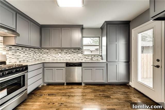 Modern kitchen with gray Shaker cabinets, granite countertops, and stainless steel appliances