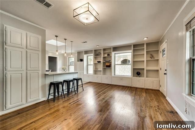 Dining area seamlessly connected to the spacious living space, featuring rich hardwood floors in this welcoming Oak Cliff home