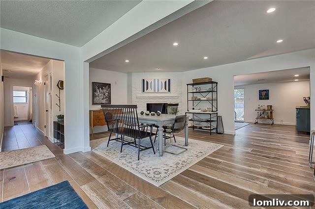 Dining area featuring a cozy brick fireplace and ample natural light