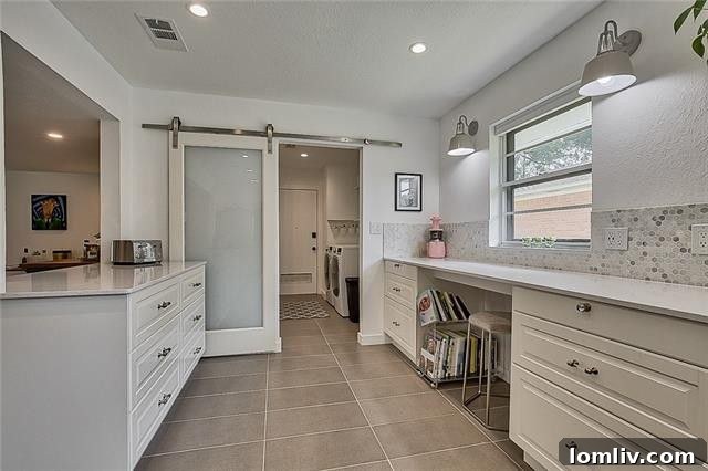 Modern laundry room and powder bath access behind a stylish barn door