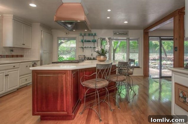 Spacious kitchen with a large island, abundant cabinetry, and quartz countertops, opening to the study and sunroom.