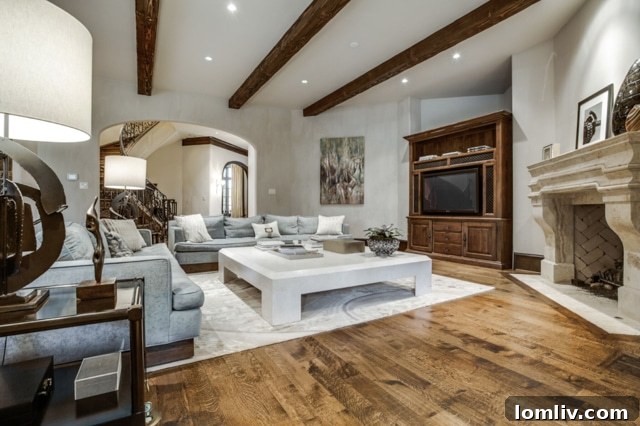 Front living room showcasing a carved stone fireplace and beamed ceiling