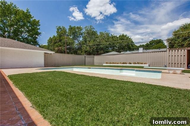 Geometric swimming pool with a chevron brick patio, perfect for outdoor entertaining