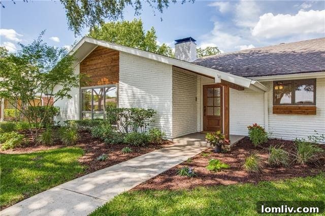 The charming exterior of the Camelot Drive home with lush landscaping in Sparkman Club Estates