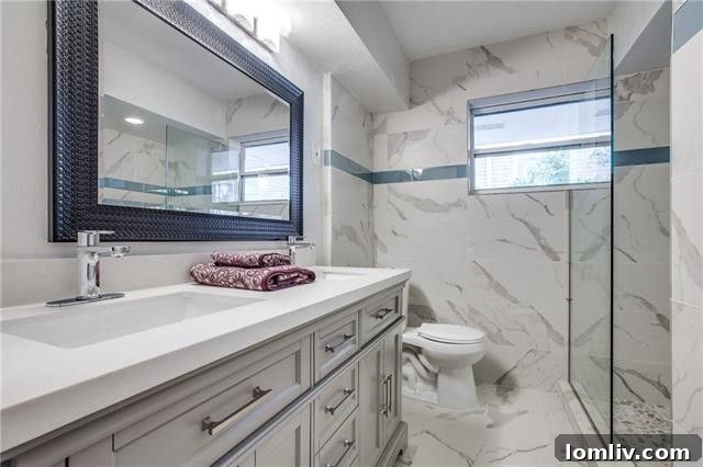 Stylish bathroom with pebble stone shower floor and frameless glass