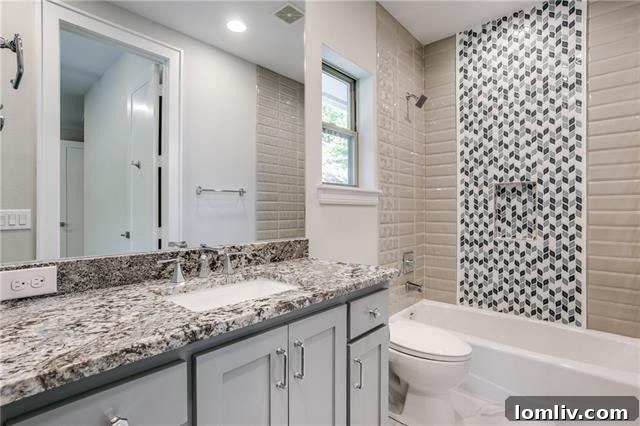 Custom secondary bathroom with designer accent tile and granite countertops.
