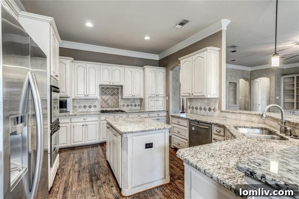 Open concept chef's kitchen with island, opening to living room and breakfast nook