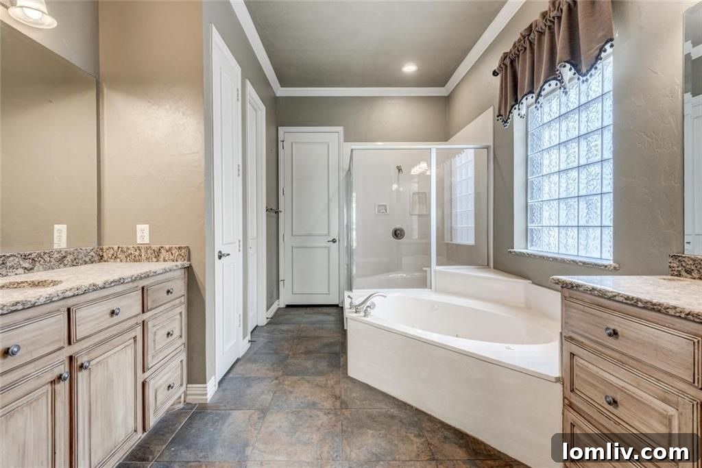 Master bath with separate shower, garden tub, and opaque glass block for privacy