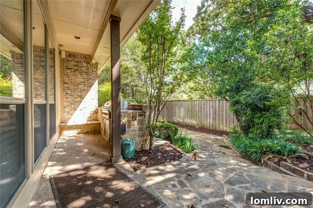 Beautifully shaded backyard with built-in outdoor grill and flagstone patio