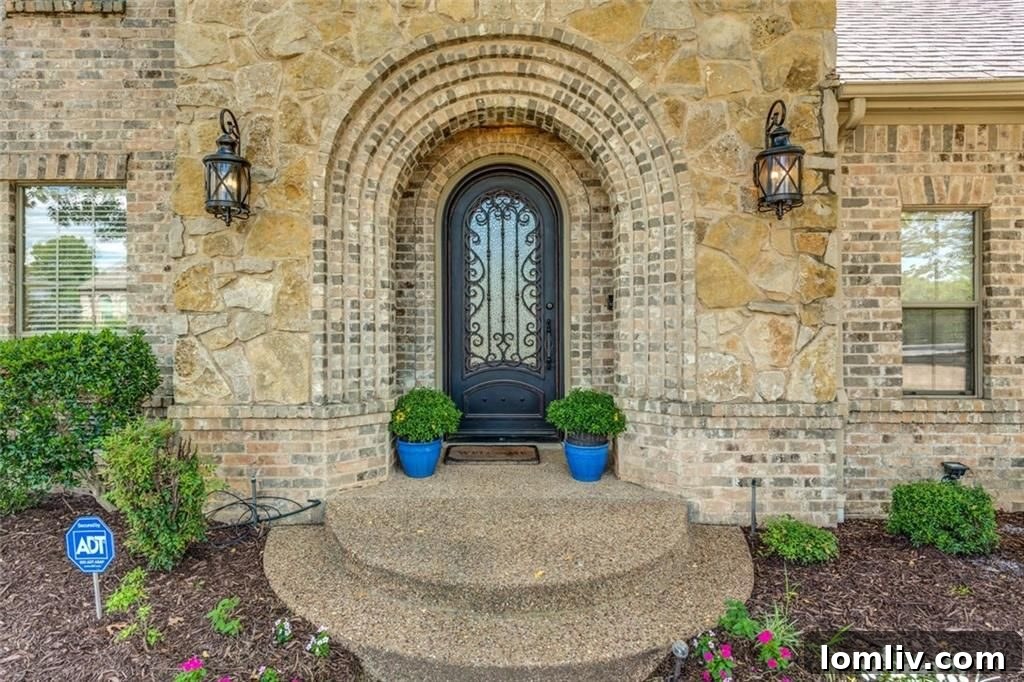 Curb appeal of Grapevine home with arched stone facade and wrought-iron front door