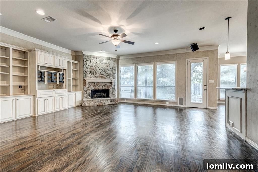 Living room with stone fireplace and built-in shelves