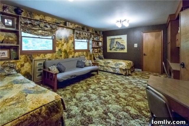 A unique room featuring green camouflage-patterned wallpaper and vintage furniture, showcasing an unconventional 1970s design choice.