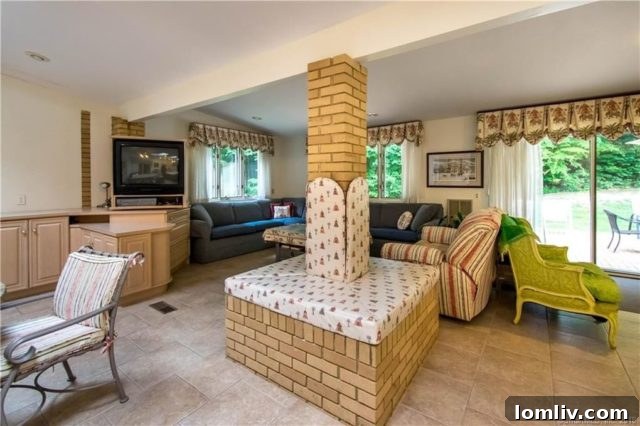 A unique architectural detail: a brick column wrapped in floral fabric-covered batting, showcasing a whimsical and personalized 1970s interior design choice.