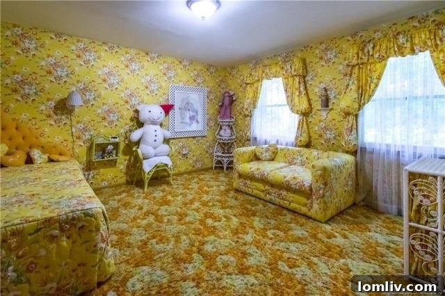 Another themed bedroom showcasing vibrant orange and pink floral wallpaper with matching curtains, embodying a quintessential 1970s aesthetic.