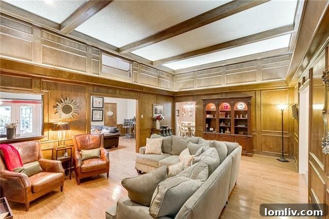 Cozy living room with exposed wood beams and a large stone fireplace, characteristic of Tudor design.