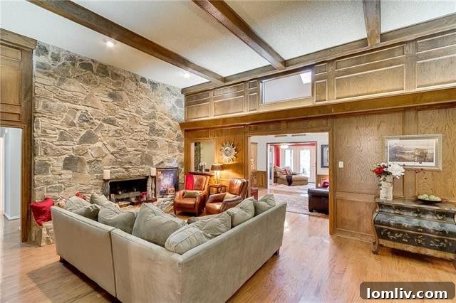 Comfortable seating area with a view of the fireplace and classic wood paneling.