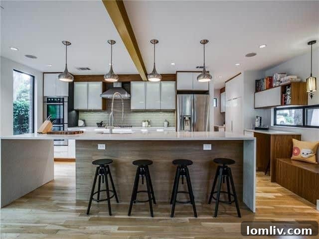 Gourmet kitchen with stainless steel appliances, large island, and waterfall counters.