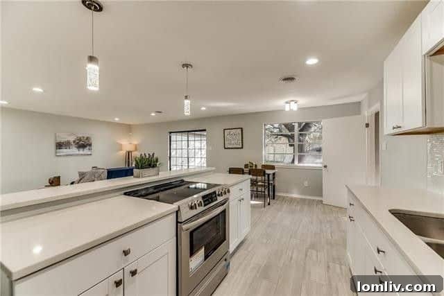 Spacious living room featuring neutral gray tones, ample natural light, and comfortable seating
