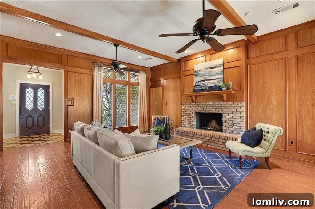 Spacious living room featuring rich wood paneling, beamed ceilings, and hardwood floors