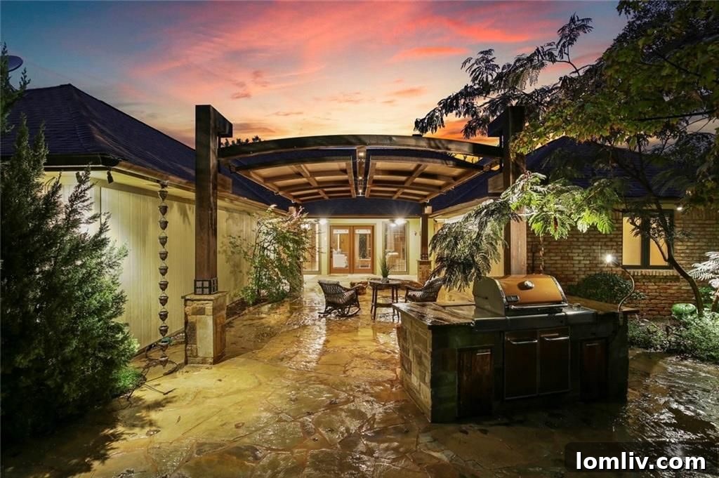 Idyllic outdoor loggia with elegant stone paving, lush landscaping, and mature trees, perfect for entertaining or relaxation